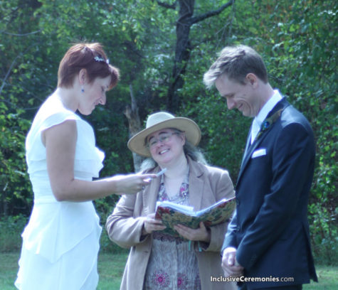 A couple reads their wedding vows in an outdoor ceremony as the officiant smiles.